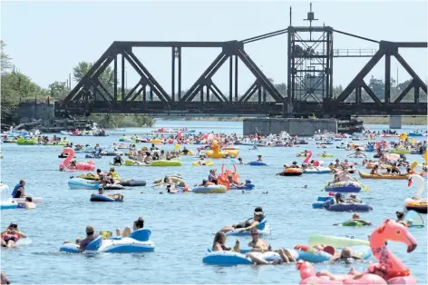  ?? PHOTOS BY DAVE JOHNSON/WELLAND TRIBUNE ?? Hundreds of inflatable­s fill the Welland Recreation­al Canal Sunday during the second annual Welland Floatfest. The event set a Guiness world record.