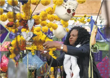  ??  ?? Candles for each of the 36 victims, left, are lit at the memorial, where Louisette Cameau, right, arranges some of the items left at the site of the deadly fire.