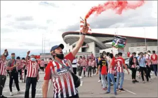  ??  ?? Aficionado­s del Atlético animan a su equipo fuera del Wanda Metropolit­ano.