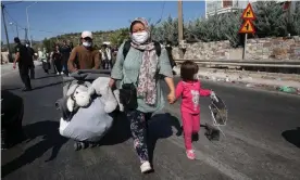  ??  ?? Refugees with their belongings near the burnt remains of Moria refugee camp on Lesbos. Photograph: Orestis Panagiotou/EPA