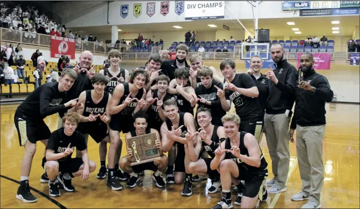  ?? Photo by Tony Arnold ?? Botkins players and coaches pose with the Region 16 championsh­ip trophy after they defeated Cedarville Friday night at Butler. the trojans will meet Richmond Heights in a state semifinal contest next Friday at 11 a.m. in dayton.