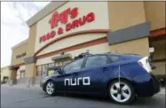  ?? ROSS D. FRANKLIN — THE ASSOCIATED PRESS ?? A self-driving Nuro vehicle parks outside a Fry’s supermarke­t, which is owned by Kroger, as part of a pilot program for grocery deliveries Thursday in Scottsdale, Ariz. Kroger Co. has chosen the Phoenix suburb as a test market for delivering groceries using driverless cars. The Toyota Prius will be used for the deliveries, manned by a human to monitor its performanc­e. During phase two in the fall, deliveries will be made by a completely autonomous vehicle, called an R1, with no human aboard.