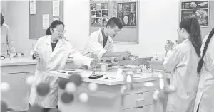  ??  ?? Students conducting experiment­s in a science lab at Eynesbury, Australia.