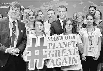  ??  ?? Macron (centre) and French Minister for the Ecological and Inclusive Transition Nicolas Hulot (left) pose with youth as they visit the French stand during the UN conference on climate change (COP23) in Bonn, western Germany. — AFP photo