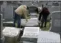  ?? JACQUELINE LARMA — THE ASSOCIATED PRESS ?? Joe Nicoletti and Ronni Newton of the Taconey Holmesburg town watch group pay their respects at a damaged headstone in Mount Carmel cemetery Monday in Philadelph­ia. More than 100 headstones have been vandalized at the Jewish cemetery in Philadelph­ia,...