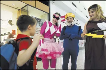 ?? ASON OGULNIK/LAS VEGAS REVIEW-JOURNAL ?? From left, Anthony Schattilly, 7, is greeted by Bridget Lasorsa, Jonathan Speregon and Jamie Rodriguez, teachers with Goldfarb Elementary School, during the Clark County School District’s Reading Rangers program kickoff Saturady at Boulevard Mall.