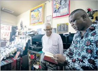  ??  ?? ESO WON BOOKS co-owner James Fugate, left, with author Scot Brown (“Fighting for Us”).