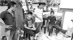  ??  ?? Chin (seated left) peering at the burnt down remnants of the house.