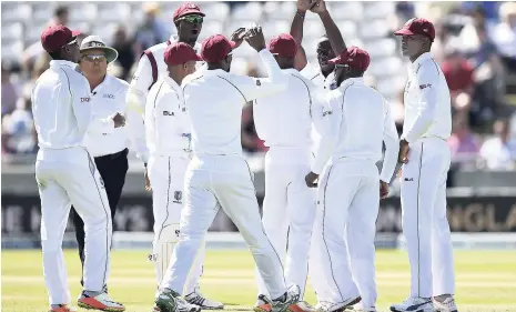  ?? FILE ?? West Indies bowler Kemar Roach (third from right) celebrates taking the wicket of England’s Mark Stoneman during day one of the first Test at Edgbaston, Birmingham, central England, last Thursday.