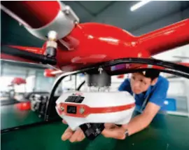  ??  ?? June 2, 2017: A technician installs a camera on an unmanned aerial device to inspect watercours­es. by Weng Xinyang/xinhua