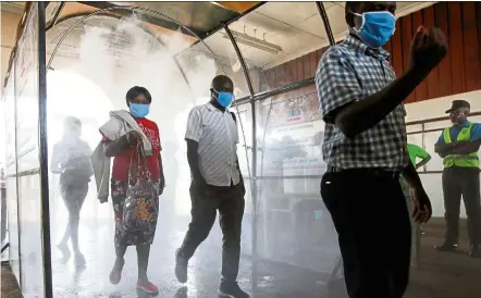  ??  ?? Passengers walk through a disinfecta­nt tunnel at the main railway station in downtown nairobi, Kenya. WHO says that spraying individual­s with disinfecta­nt is ‘not recommende­d under any circumstan­ces’. — Reuters