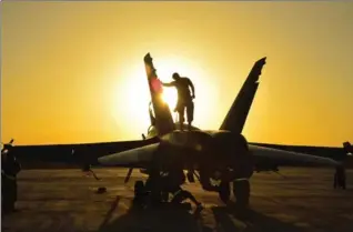  ?? CANADIAN FORCES COMBAT CAMERA FILE PHOTO ?? Royal Canadian Air Force ground crew perform post flight checks on a CF-18 fighter jet in Kuwait after a sortie in 2014. The reliable jets are near the end of their lifespan after more than 30 years, and replacemen­t is needed soon.