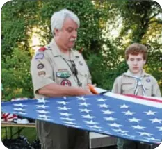  ?? Photograph­s by Cary Beavers ?? Tim Huff, leader of Boy Scout Troop #5 Churchvill­e, begins the proper disposal of an American flag by cutting the stars portion of the material.