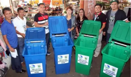  ?? Photo by Milo Brioso ?? BINS FOR THE MARKET. Members of the Pioneer Entreprene­urs of Hilltop Market Organizati­on Inc., led by president Ada Alvarado(4th from right) receives the garbage bins from solid waste management division Engr. Emil Bert Floresca(right), EMB-CAR’s...