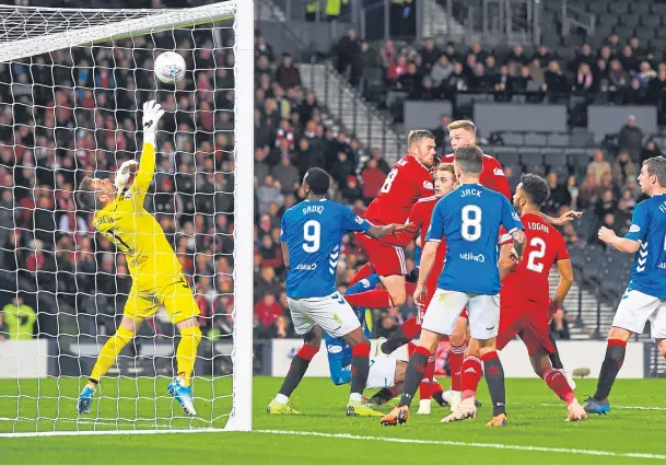  ??  ?? Game’s defining moment: Lewis Ferguson rises highest to bullet home the game’s only goal from a Niall McGinn corner and send the Dons into the final