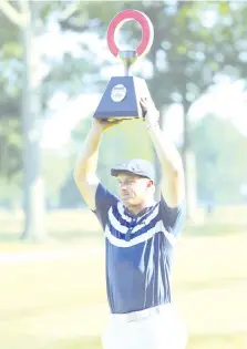  ?? - AFP photo ?? DeChambeau celebrates with the trophy after winning the Rocket Mortgage Classic at the Detroit Golf Club in Detroit, Michigan.