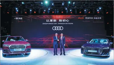  ?? PHOTOS PROVIDED TO CHINA DAILY ?? Rupert Stadler (left), CEO of Audi AG, and Xu Liuping, chairman of FAW Group’s Board of Directors attend an Audi brand event at Auto China 2018 in Beijing on Wednesday. The all-new Audi Q5L is set to go into production this month at FAW-Volkswagen...