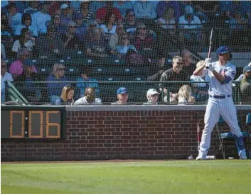  ?? E. JASON WAMBSGANS/CHICAGO TRIBUNE PHOTOS ?? A Cubs player warms up in the on-deck circle with the pitch clock counting down during a Cactus League game against the Giants on Saturday in Mesa, Ariz. The Cubs won their spring opener 10-8.