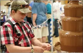  ?? ELI STILLMAN — PARADISE POST FILE ?? Jeremiah Harmantas tries out the fondue fountain at the 12th annual Paradise Chocolate Fest on May 13, 2017, in Paradise. On Saturday the festival returns to Paradise.