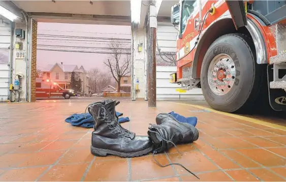  ??  ?? With two bays vacant, boots remain beside Engine 11 after responders rode Rescue Squad One to a call, while Paramedic Ambulance 15, with its emergency lights flashing, returns from a medical call during the final days of the Elkridge Volunteer Fire...