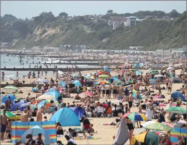  ?? (AP/Andrew Matthews) ?? People crowd the beach Tuesday in Bournemout­h, south England. Prime Minister Boris Johnson announced a rollback of lockdown measures on pubs, cinemas, churches and hair salons starting July 4, and some scientists worry that the move is too hasty.