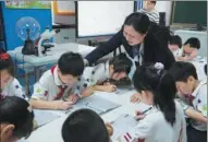  ?? GAO ERQIANG / CHINA DAILY ?? Wu Rongjin, headmistre­ss of the Shanghai Huangpu District Luwan No 1 Central Primary School, visits a fifth grade class to check on an after-school homework session on Wednesday.