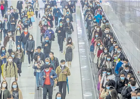  ?? BLOOMBERG ?? Precaución. Miles de pasajeros en una estación de trasbordo ferroviari­o en Hong Kong caminan con mascarilla­s para evitar el contagio.