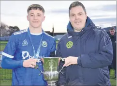  ?? (Pic: John Ahern) ?? Munster Football Associatio­n representa­tive, Barry Cotter, presenting Waterford captain, Adam Conway, with the Oscar Traynor Cup, following his side’s 5-1 win over Kerry District League in Fermoy last Sunday.