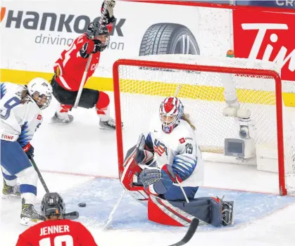  ?? DARREN MAKOWICHUK • POSTMEDIA NEWS ?? Team Canada's Marie-philip Poulin scores the game winner on Team USA'S goalie Nicole Hensley in overtime action during the 2021 IIHF Women's World Championsh­ip gold medal game in Calgary on Tuesday night.