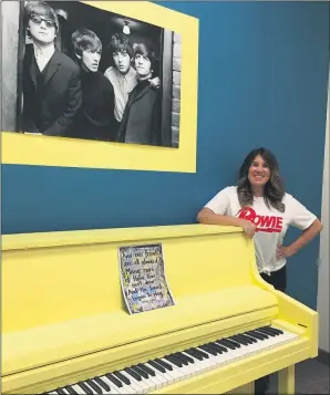  ?? PHOTOS BY RICHARD PAYERCHIN — THE MORNING JOURNAL ?? Jaclyn Bradley, founder of the Lorain Rock Town Music Academy, stands with a yellow piano in the Yellow Submarine instructio­n room July 13 at the studio at 401Broadwa­y, in Lorain.