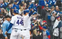  ?? Associated Press photo ?? Chicago Cubs' Anthony Rizzo (44) and Javier Baez (9) react after they score during the fifth inning of a baseball game against the St. Louis Cardinals on Sunday in Chicago.