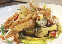  ??  ?? Grilled butterflie­d shrimps with marble potatoes, roasted cauliflowe­r and corn salsa