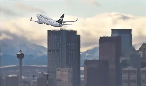  ?? GAVIN YOUNG / POSTMEDIA NEWS ?? A WestJet Boeing 737 takes off from the Calgary Internatio­nal Airport early in 2020. The coronaviru­s pandemic has devastated the airline industry.