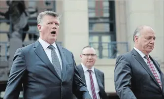  ?? CHIP SOMODEVILL­A GETTY IMAGES ?? Kevin Downing, left, Brian Ketcham and Thomas Zehnle, lawyers for former Trump campaign chairman Paul Manafort, leave the courthouse in Alexandria, Virginia, on Friday.