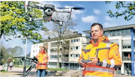  ?? FOTO: STEPHAN KÖHLEN ?? Eine Drohne steigt auf dem unteren Neuen Markt auf. Drohnenpil­ot André Hallscheid­t (vorn) lenkt das Fluggerät. Im Hintergrun­d Wilhelm Dresselhau­s mit einem Bodenradar.