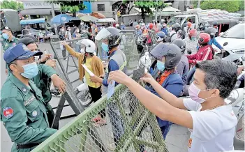  ?? — AFP photo ?? Police block motorists from passing a checkpoint set up in capital Phnom Penh and neighbouri­ng Ta Khmau town and Kandal province.