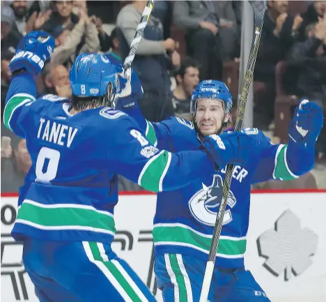  ?? JEFF VINNICK/NHLI VIA GETTY IMAGES ?? The Canucks’ Chris Tanev is congratula­ted Oct. 12 on his goal scored against the Winnipeg Jets by teammate Michael Del Zotto, a defenceman Vancouver signed in the off-season to strengthen the team’s power play, which is still sputtering at just 8.7 per...