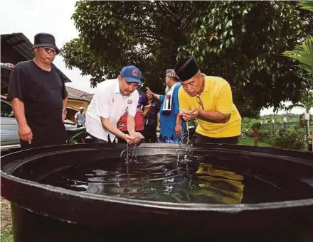  ?? BERNAMA PIC ?? Johor Housing and Local Government Committee chairman Datuk Mohd Jafni Md Shukor (second from left) checking water stored in a tank at Felda Bukit Permai in Kulai, yesterday.