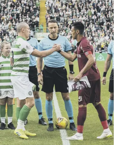  ??  ?? 0 Celtic captain Scott Brown shakes hands with his Cluj counterpar­t Mario Camora before the teams’ Champions League third qualifying round second-leg encounter at Parkhead last August.