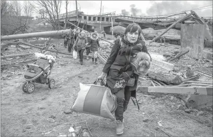  ?? ?? Ucranios abandonan este domingo la ciudad de Irpin –cerca de Kiev– mediante un sendero improvisad­o junto a un puente destruido. Foto Ap