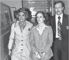  ?? ASSOCIATED PRESS ?? Patty Hearst, center, daughter of California newspaper magnate Randolph Hearst, is escorted by U. S. marshals in 1976.