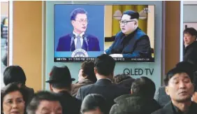  ?? ASSOCIATED PRESS FILE PHOTO ?? People watch a TV screen showing images of North Korean leader Kim Jong Un, right, and South Korean President Moon Jae-in at the Seoul Railway Station in Seoul, South Korea.