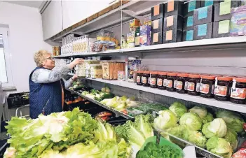  ?? RP-FOTO: J. KNAPPE ?? Susanne Nagy räumt in der Brüggener Tafel Lebensmitt­el ins Regal. Die Einrichtun­g setzt auf getrennte Warteberei­che für deutsche und ausländisc­he Bedürftige.