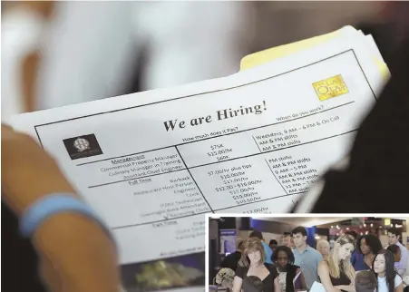  ?? AP FILE PHOTOS ?? THEY’RE HIRING: An applicant looks at job listings, above, for the Riverside Hotel, and job seekers, right, talks to representa­tives of Aldi at a job fair in Sunrise, Fla., in June.