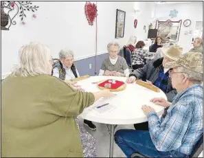  ?? (NWA Democrat-Gazette/Lynn Kutter) ?? Janet Funk (left) deals playing cards for a game of Tic at Lincoln Senior Center. Two tables of Tic were underway this day at the center.