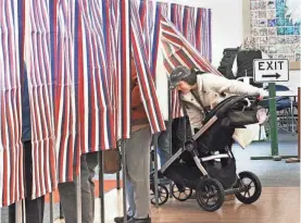  ?? ?? Hampton voter Colleen Poisson and her daughter Ellie negotiate booth space for the stroller at the polls on Tuesday.