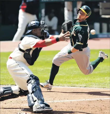  ?? ASSOCIATED PRESS ?? TONY DEJAK Eric Sogard beats the throw to Indians catcher Carlos Santana to score on Josh Donaldson’s single in the fifth inning. The Athletics outscored the Indians 30-6 in a three-game sweep.