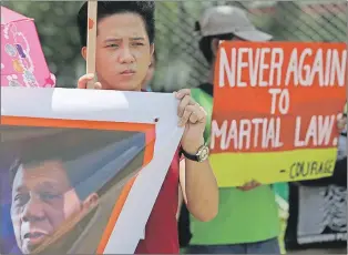  ?? AP PHOTO ?? Filipino activist holds a slogans with a picture of Philippine President Rodrigo Duterte as they oppose his declaratio­n of martial law during a rally in Manila, Philippine­s Friday.