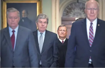  ?? DREW ANGERER/GETTY IMAGES ?? Sens. Lindsey Graham and Roy Blunt, Supreme Court Chief Justice John Roberts and Sen. Patrick Leahy arrive at the Senate chamber for impeachmen­t proceeding­s Thursday.