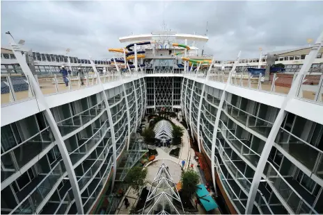  ??  ?? The upper deck of Harmony of the Seas, above; lavish interior of Symphony of the Seas, left, and exterior, right, at its shipyard in France. The world’s lagest cruise ship, it is scheduled to launch in April